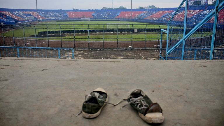 A pair of sneakers sit trampled in the stands of Kanjuruhan Stadium following a deadly soccer match stampede, in Malang, East Java, Indonesia, Sunday, Oct. 2, 2022. Panic at an Indonesian soccer match after police fired tear gas to to disperse supporters invading the pitch left over 100 people dead, mostly trampled to death, police said Sunday. (AP Photo/Hendra Permana)